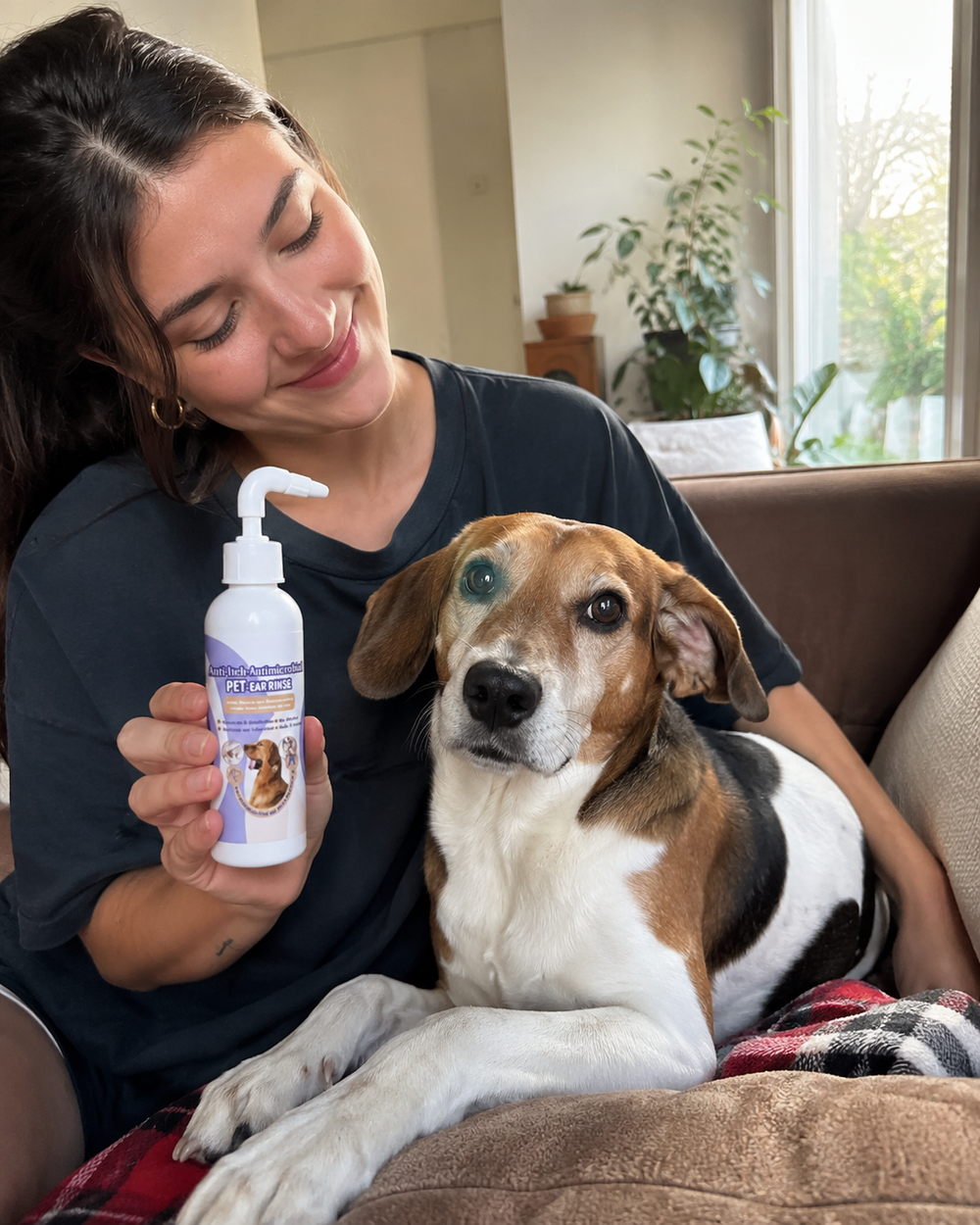 Dog relaxing beside its owner holding the ear rinse bottle
